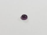 a close up of a purple gemstone on a white surface