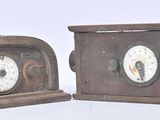 two clocks that are sitting side by side on a table