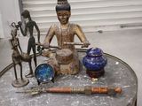 a statue of a man sitting on top of a table next to other items