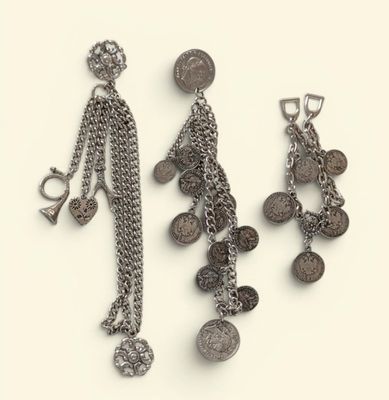 two pairs of earrings with coins hanging from them on a white surface