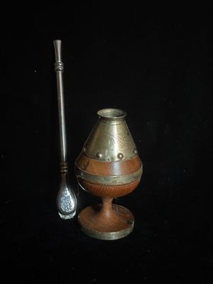un petit vase et une cuillère posés sur une surface noire