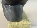 a black sculpture of a hand holding a black object