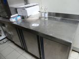 un plan de travail en acier inoxydable sur lequel sont posées deux bouteilles d'eau