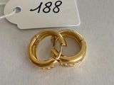 two gold rings on a white table with a price tag