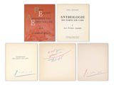 quatre livres portant des autographes et des signatures sont posés sur une surface blanche