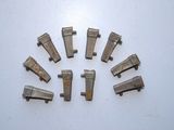six pièces métalliques sont disposées en cercle sur une surface blanche