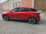 the rear end of a red car parked in front of a building