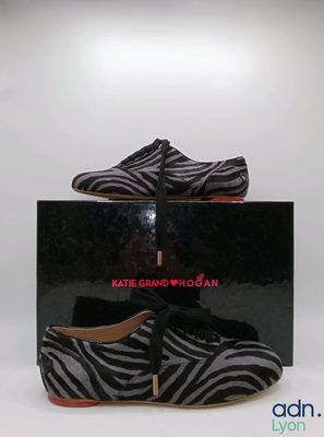 une paire de chaussures à imprimé zèbre noir et blanc avec des semelles rouges