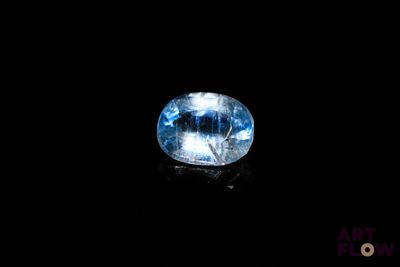 a close up of a blue topazte gems on a black surface