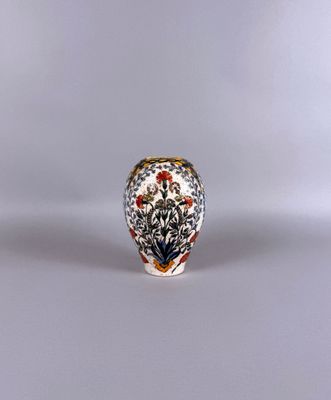 un petit vase orné de fleurs, posé sur une table