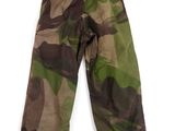 a camouflage pants hanging on a hanger against a white wall