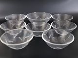 six bols en plastique transparent posés sur une table noire