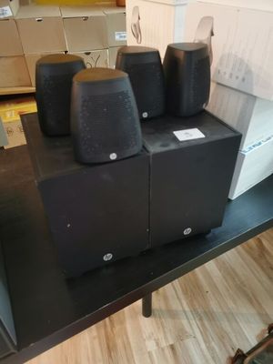 four speakers sitting on a black table in a living room