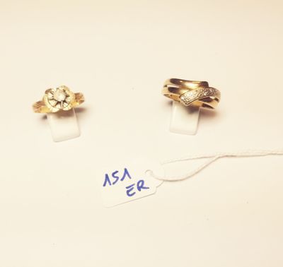 two gold rings and a diamond ring on a white surface