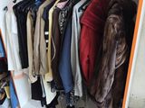 a lot of clothes hanging on a rack in a closet