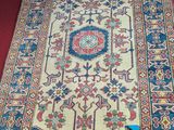 an image of a rug on the floor with a red wall behind it