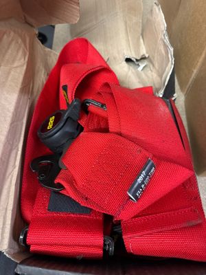 une boîte contenant un ruban rouge et une paire de ciseaux