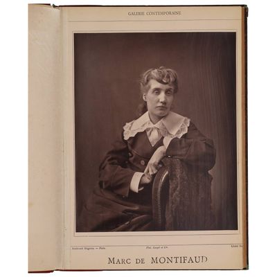 une vieille photo d'une femme assise sur une chaise, vêtue d'une chemise à col
