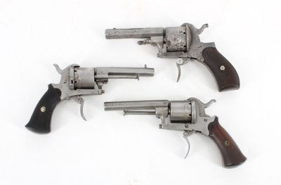 three revolvers are shown on a white surface with a white background