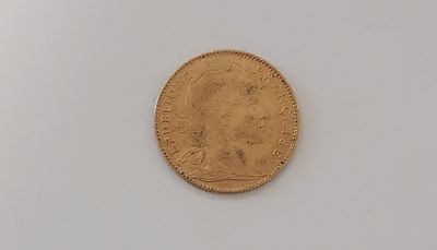 une vieille pièce d'or sur une surface blanche avec un fond blanc