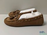 tan sued moccali slippers with bows and bows on them