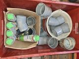 une caisse rouge remplie de seaux et de bidons posée sur une table en bois
