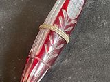 a red pen that is laying on a black surface