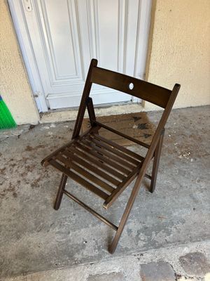 une chaise en bois posée sur le sol en béton à l'extérieur d'un immeuble