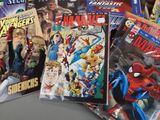 many comic books on the table and one has a spider - man