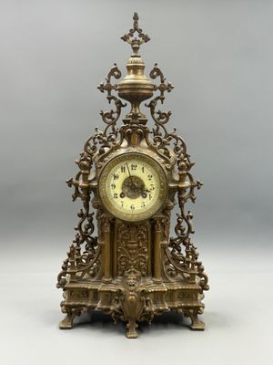 a gold clock sitting on top of a table
