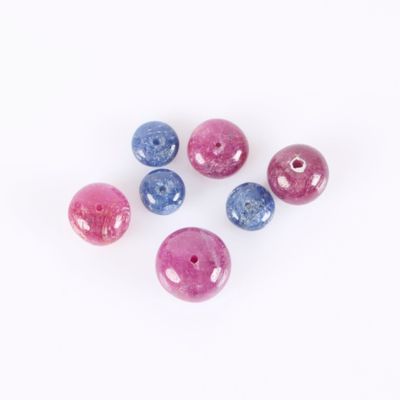 six pink, blue and purple beads on a white background