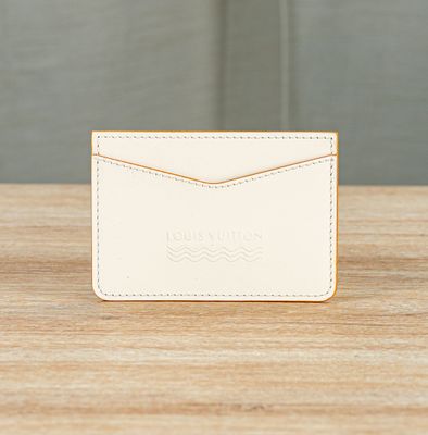 a white card case sitting on top of a wooden table