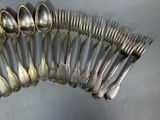 a lot of silver spoons and forks arranged in a circle