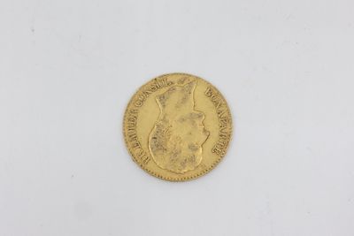 a gold coin on a white surface with a white background