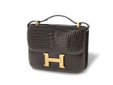 a brown crocodile skin handbag with gold hardware on the handle