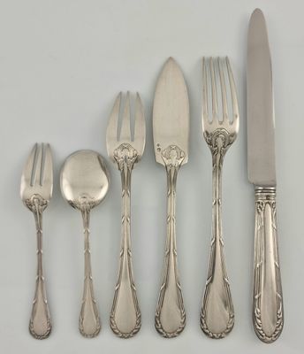 five forks, a spoon, and a knife on a table