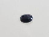 a blue sapphire stone on a white surface
