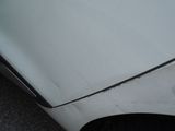 a white car that has a dent in the front of it