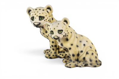 two figurines of two cheetah sitting next to each other