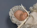 a baby doll with a bonnet on it ' s head