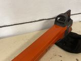 an orange and black hand held stapler sitting on top of a table