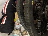 a bike tire sitting on the ground next to a pile of items