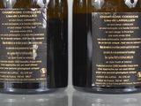 two bottles of wine sitting on top of a table next to each other