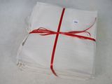 a stack of four white napkins tied with a red ribbon