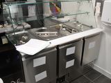 une photo d'une cuisine professionnelle équipée de plans de travail et d'éviers en acier inoxydable