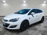 a white car is parked on a checkered floor in a garage