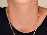 une femme portant un t-shirt noir et un collier à chaîne dorée