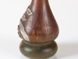a brown vase that has a bird on it
