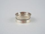 gros plan d'une bague en argent sur une surface blanche