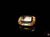 a close up of a yellow diamond on a black surface